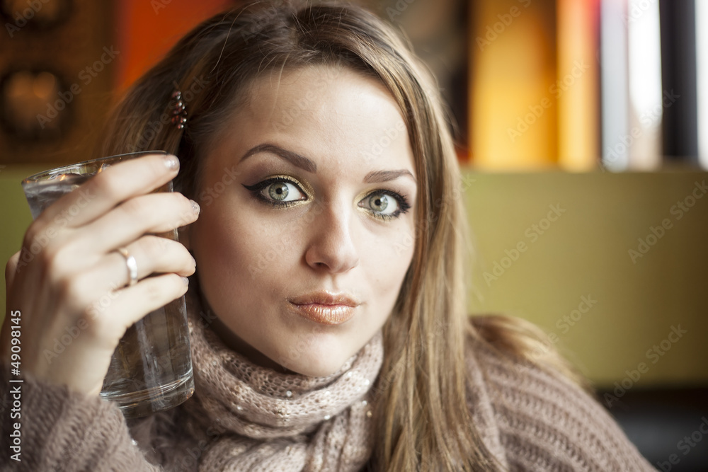 Young Woman with Beautiful Blue Eyes Drinking Water
