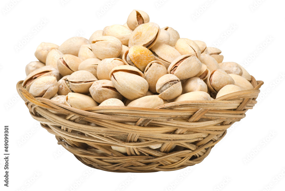 Pistachio nuts in a wicker plate, isolated Pistachio nuts in a wicker plate, isolated