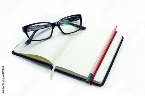 Pencil and black frame glasses on the notebook