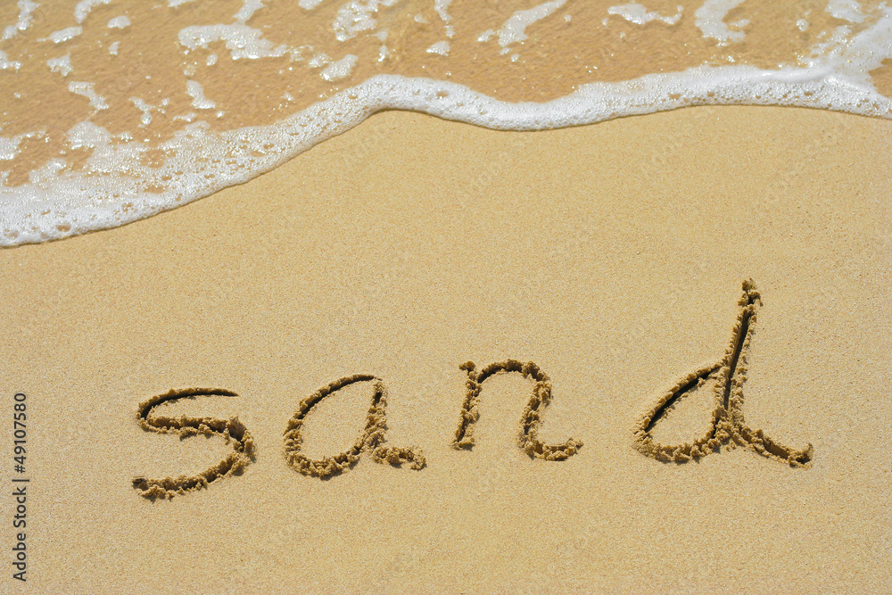 Conceptual hand made or handwritten sand text in sand