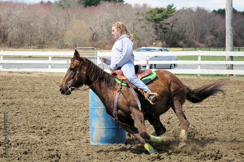 Young blonde woman barrel racing