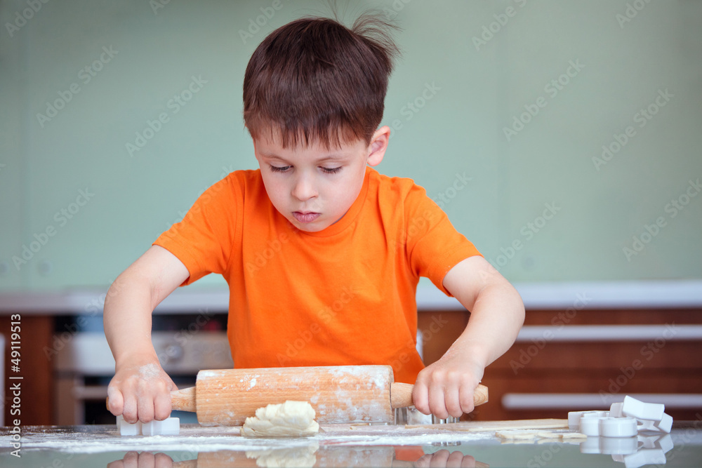 Little boy with rolling pins baking Little boy with rolling pins baking