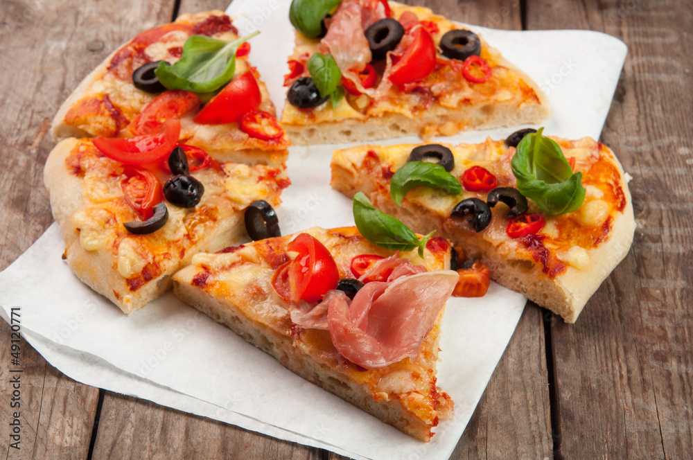 Pizza with ham, pepper and olives on old wooden background Pizza with ham, pepper and olives on old wooden background