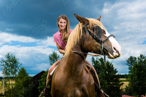 Young woman riding the horses on the meadow