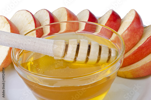 Fototapeta Cut into slices of apples with a bowl of honey