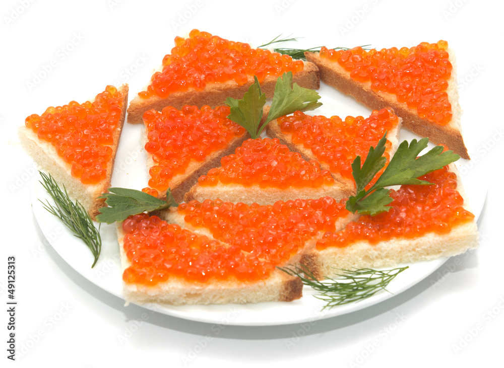 Red caviar on bread on white plate close-up Red caviar on bread on white plate close-up