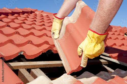 Construction worker tile roofing repairs