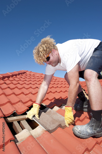 Construction worker tile roofing repairs