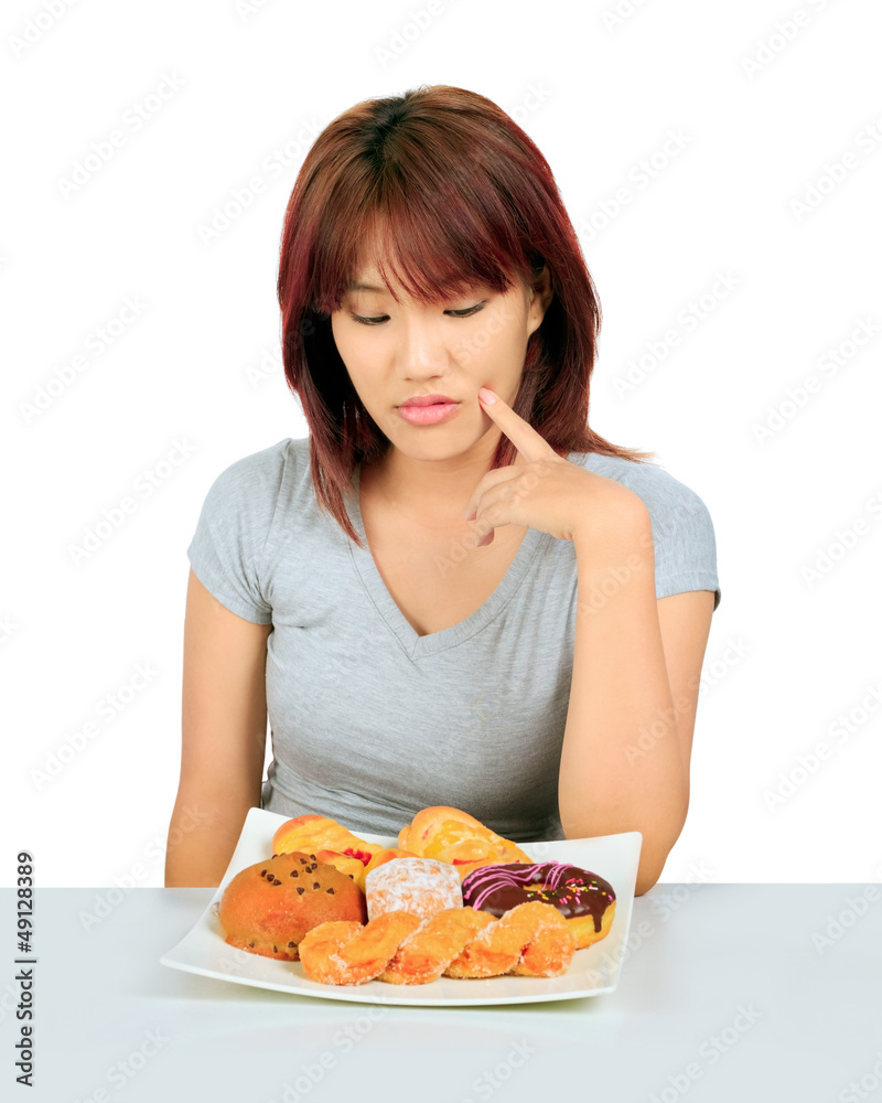 Isolated young asian woman with a donuts on the table Isolated young asian woman with a donuts on the table
