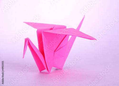 Origami crane on purple background.
