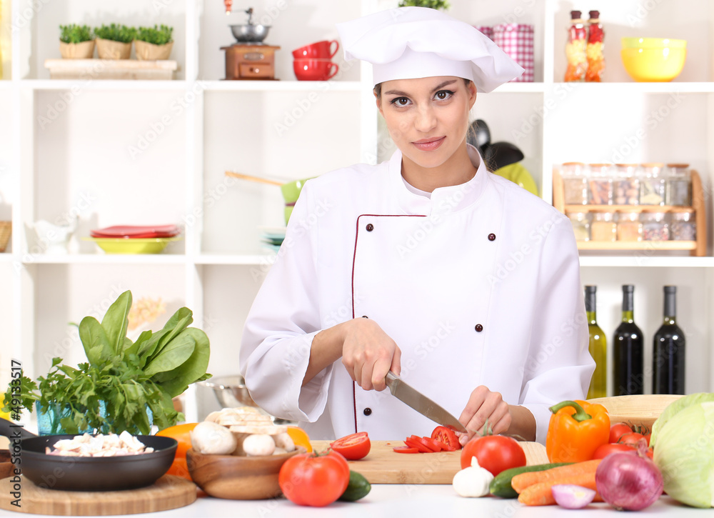 Young woman chef cooking in kitchen Young woman chef cooking in kitchen