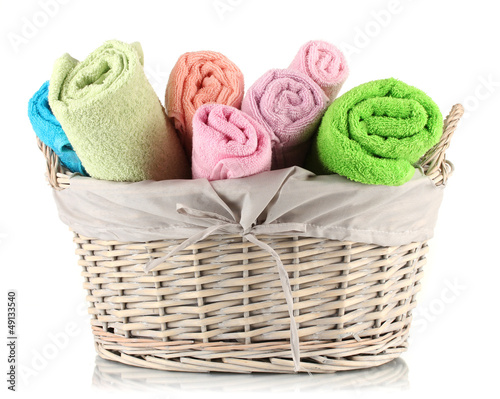 Colorful towels in basket isolated on white