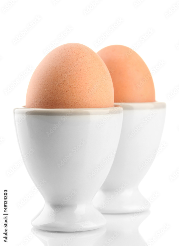 Whole boiled eggs in egg cups, isolated on white Whole boiled eggs in egg cups, isolated on white