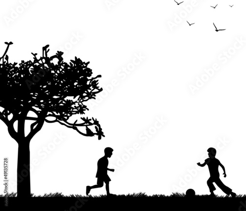 Little boys playing with ball on spring field silhouette