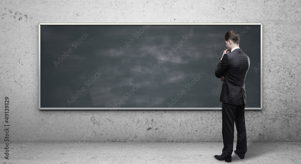 man looking at blackboard