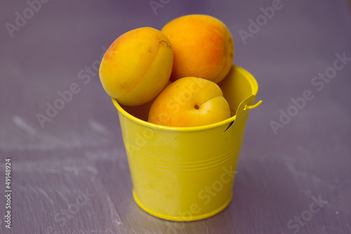 Apricots in a small yellow bucket