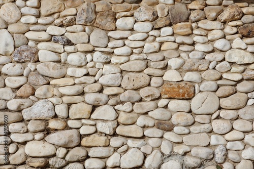 Texture of stone wall built of irregular pebbles