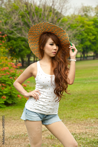 Pretty Asian woman in posing with hat .