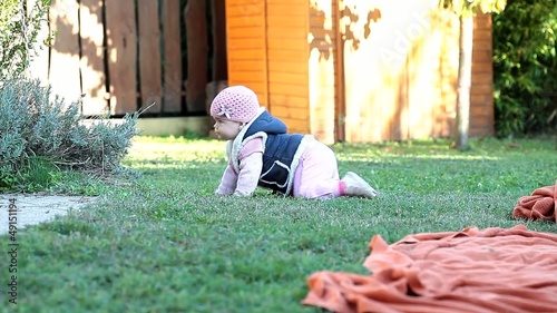Cute babygirl outdoors playing on a grass