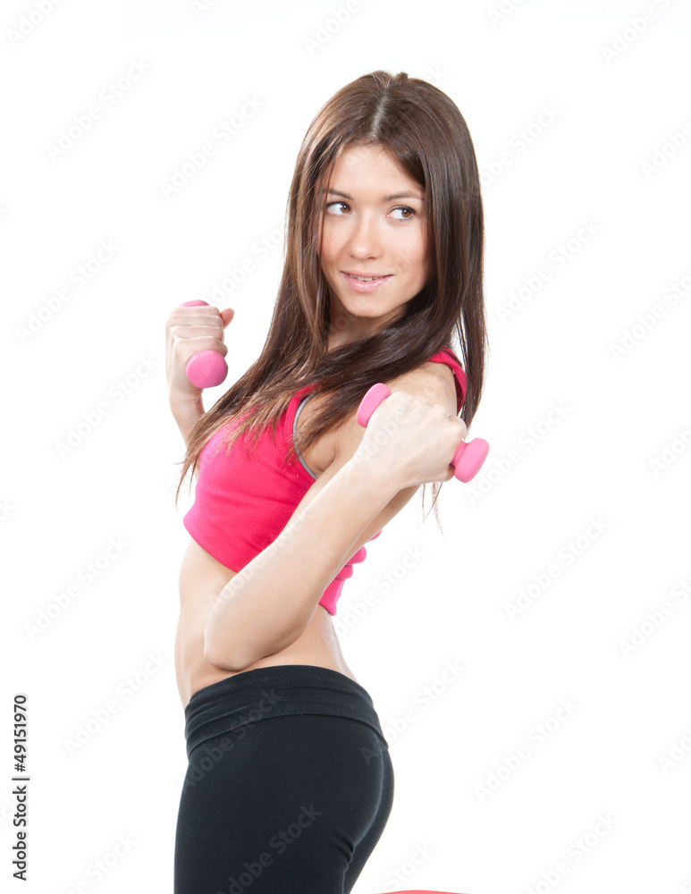 Sport woman on diet standing sideways, holding pink dumbbells Sport woman on diet standing sideways, holding pink dumbbells