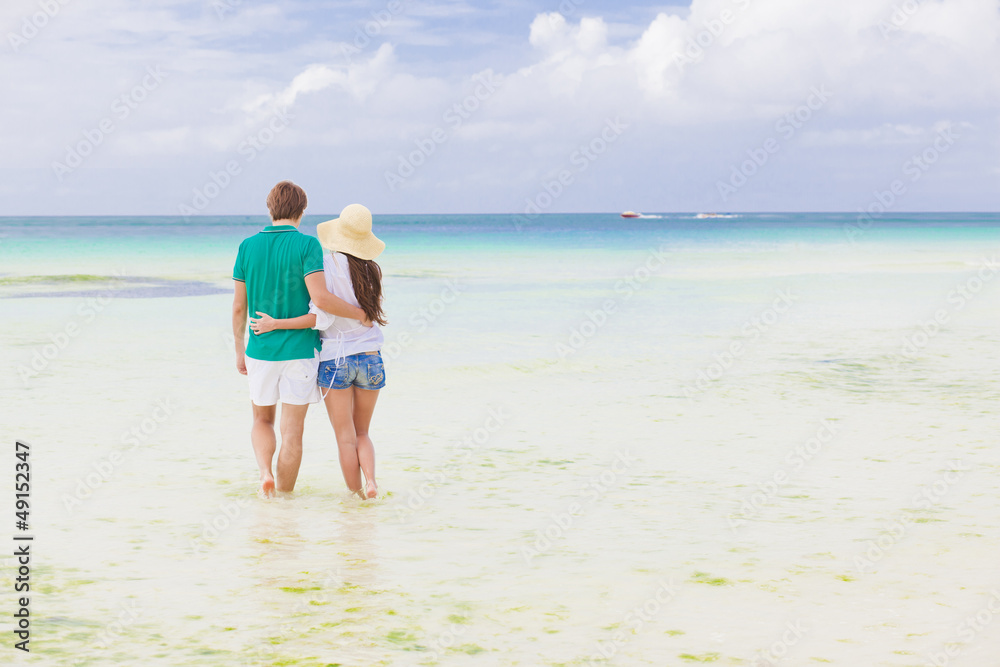 Young happy couple walking on beach