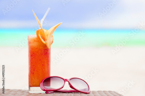 picture of fresh tropical juice and sunglasses on tropical beach