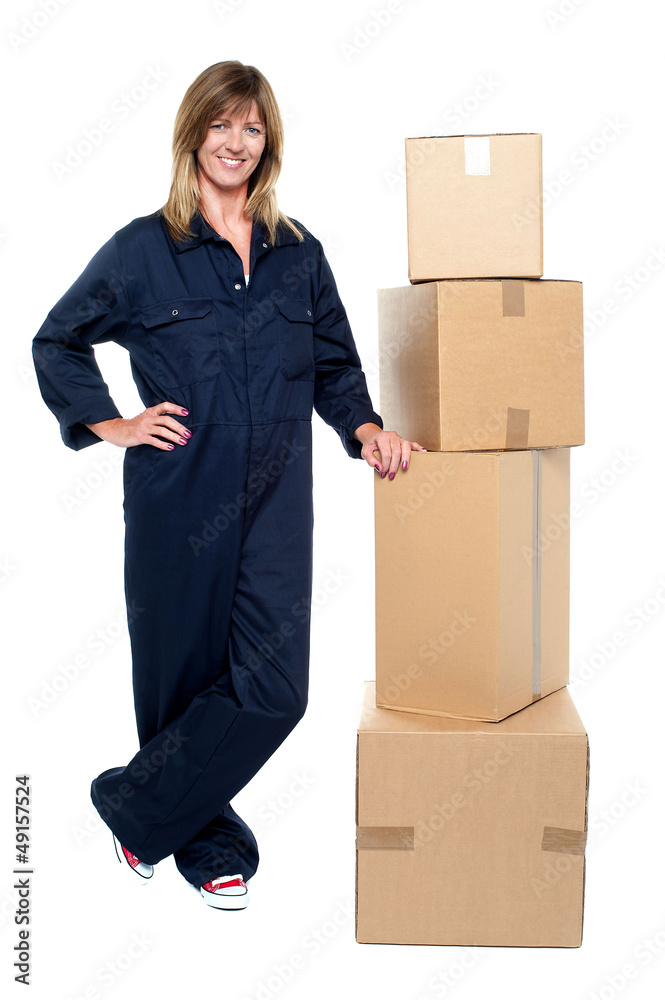 Beautiful delivery woman standing beside cartons Beautiful delivery woman standing beside cartons