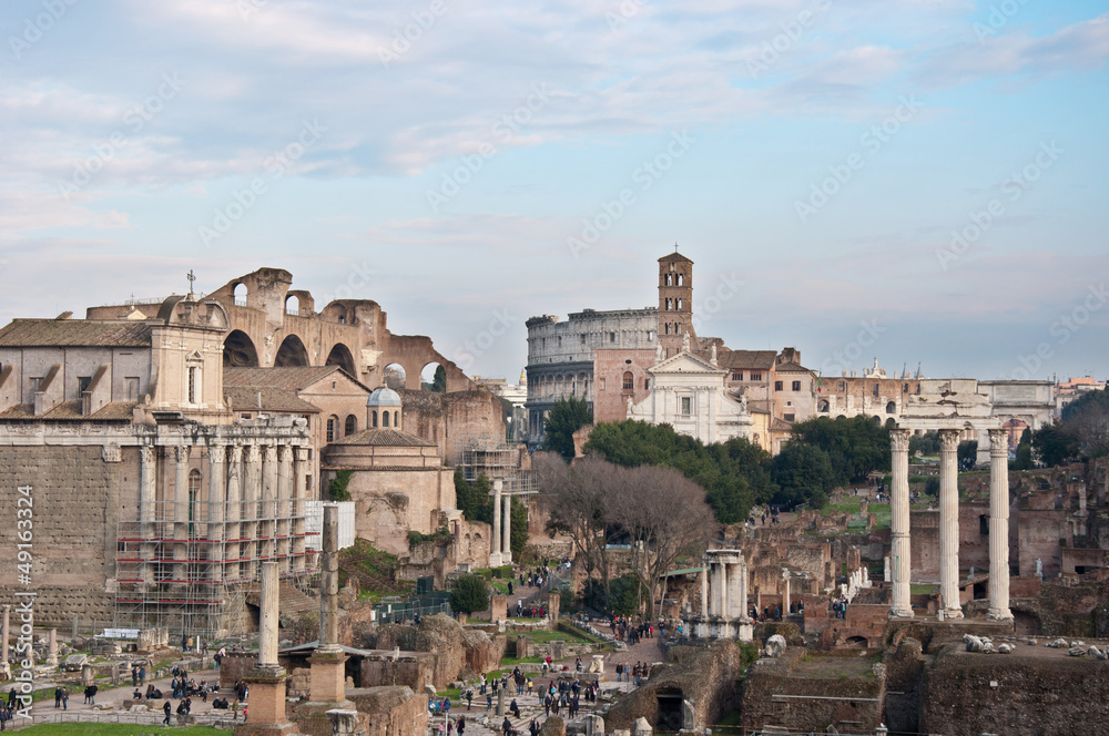 Roman forums with tourists and coliseum on background
