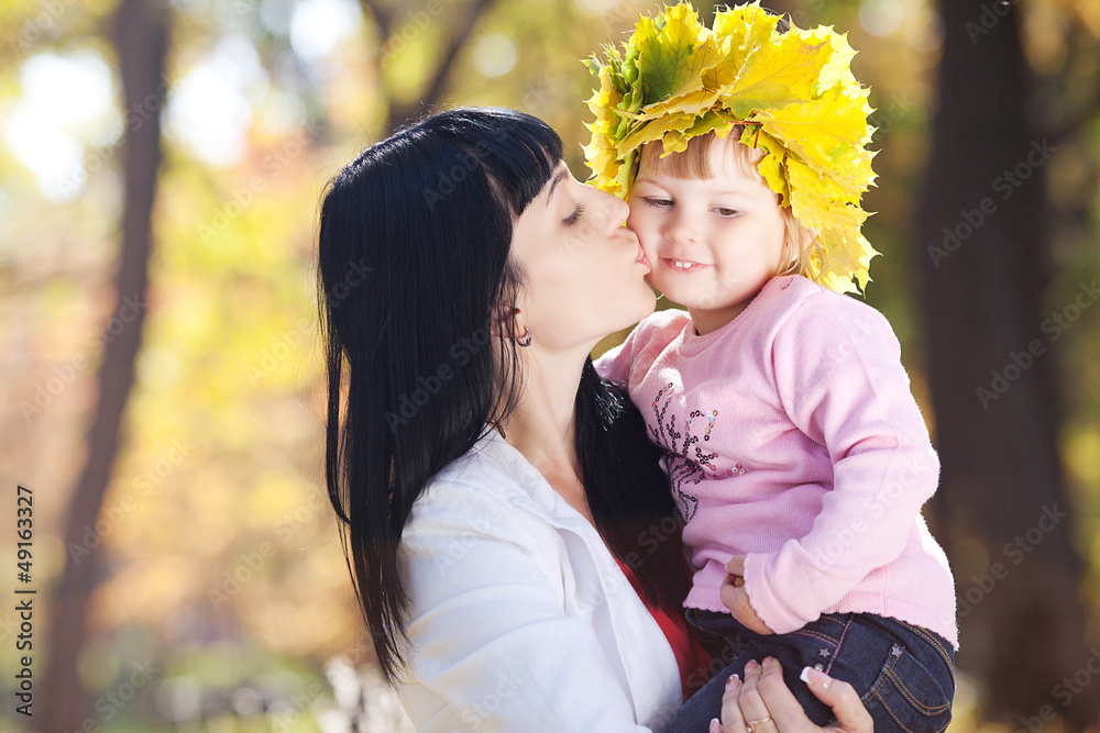 beautiful young mother holding her daughter in a wreath of maple beautiful young mother holding her daughter in a wreath of maple