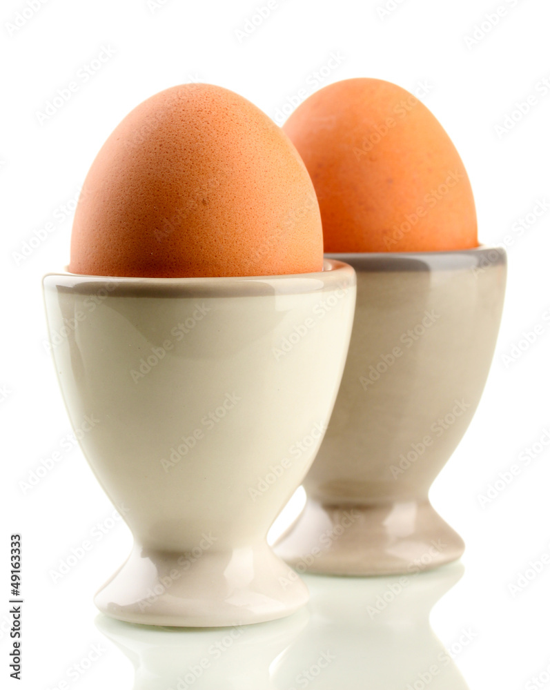 Whole boiled eggs in egg cups, isolated on white Whole boiled eggs in egg cups, isolated on white
