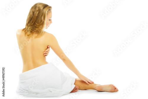 young woman in towel terry sits on floor