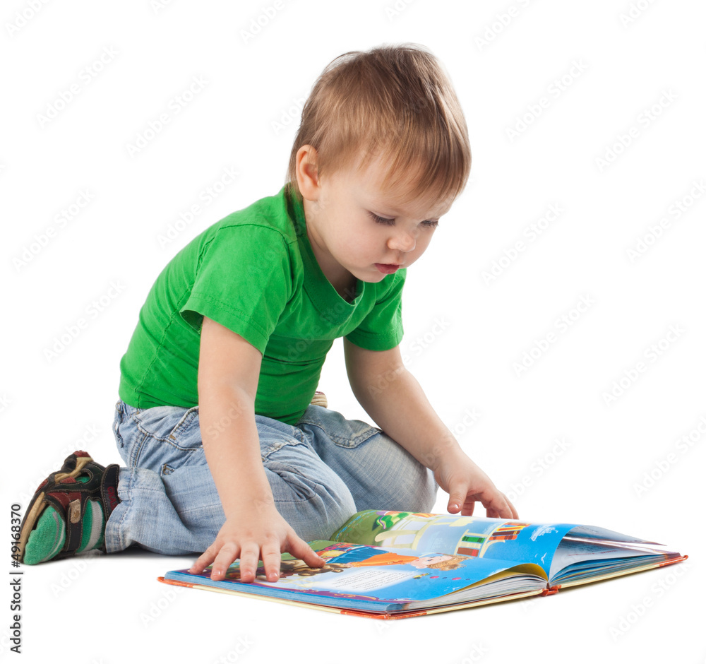 Little boy with a book sitting on the floor Little boy with a book sitting on the floor