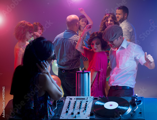 young couple dancing at party with female dj