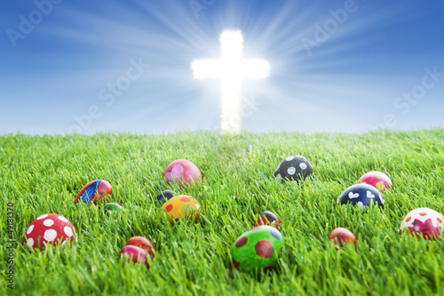 Easter eggs and Cross on grass photo