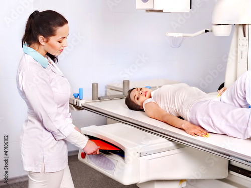 Patient  in x-ray room looking at doctor.