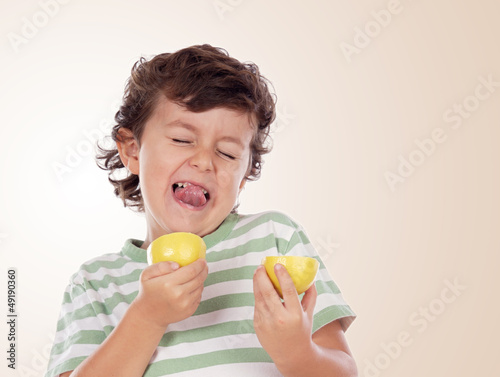 Cute child eating a lemon photo