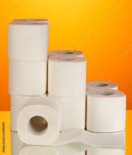 Rolls of toilet paper on orange background
