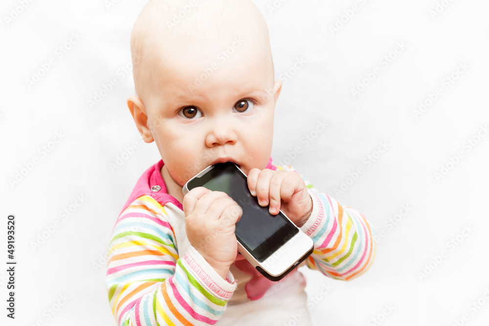 Baby chews on a mobile phone