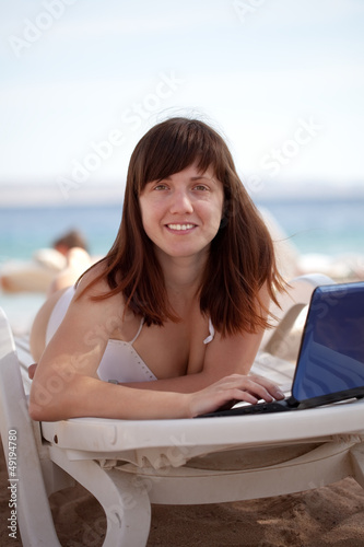woman using laptop at resort beach