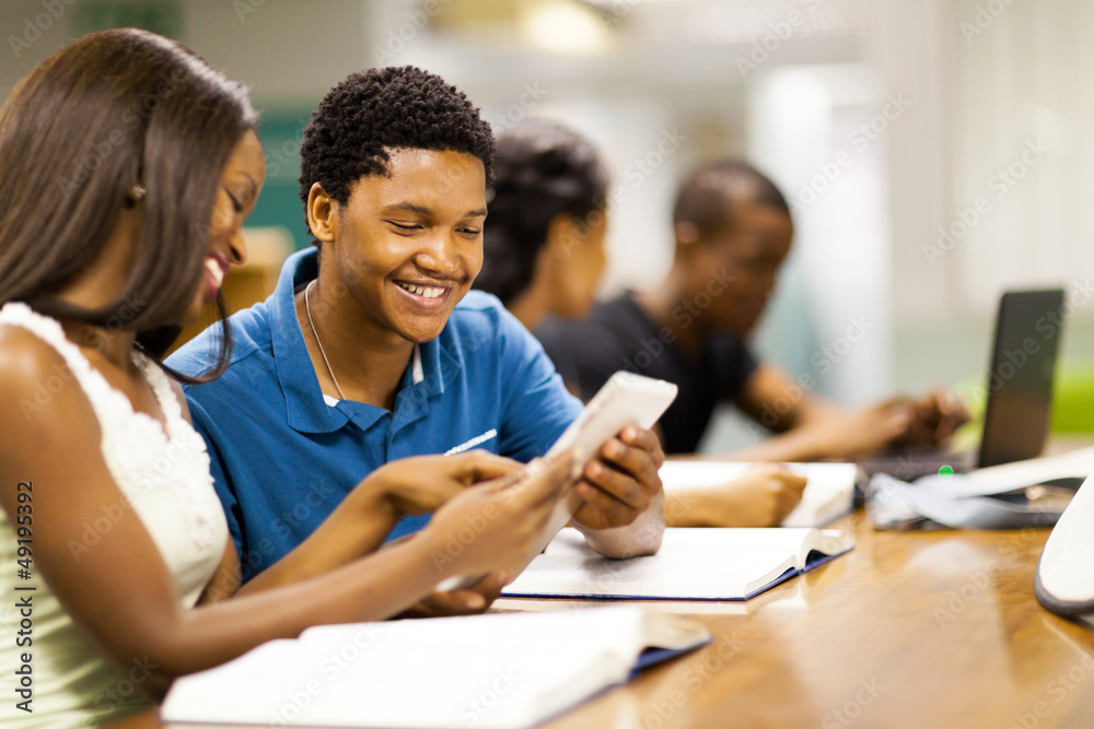happy african college students using tablet computer together happy african college students using tablet computer together