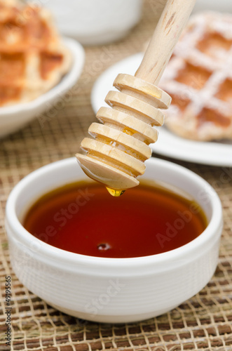 Bowl of honey with wooden dipper
