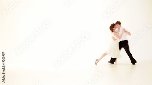 passionate, young couple showing dance moves on white background