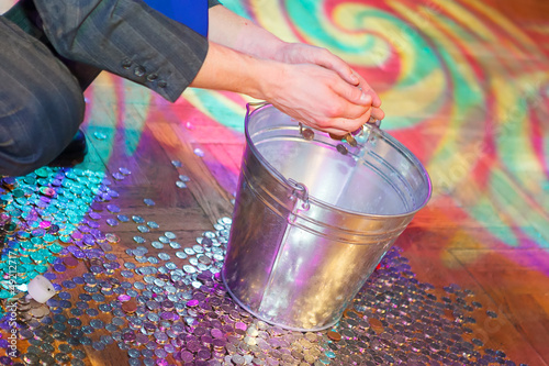 Coins on the floor being thrown into a bucket photo