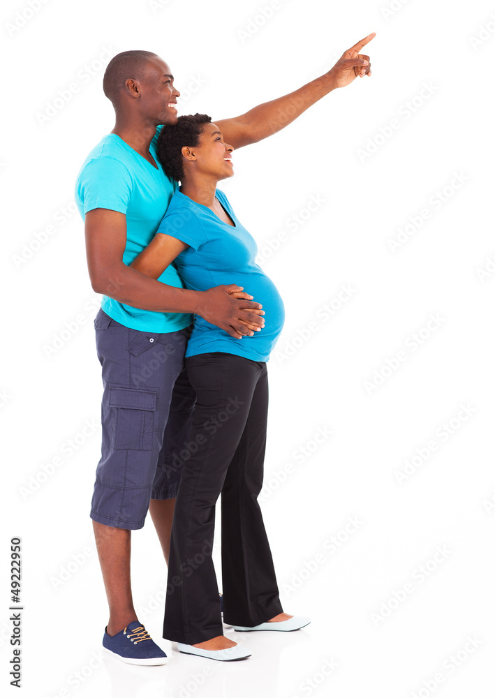 Fototapeta premium expecting african american couple pointing at empty copy space