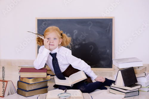 девочка  сидит с пером и книгами
