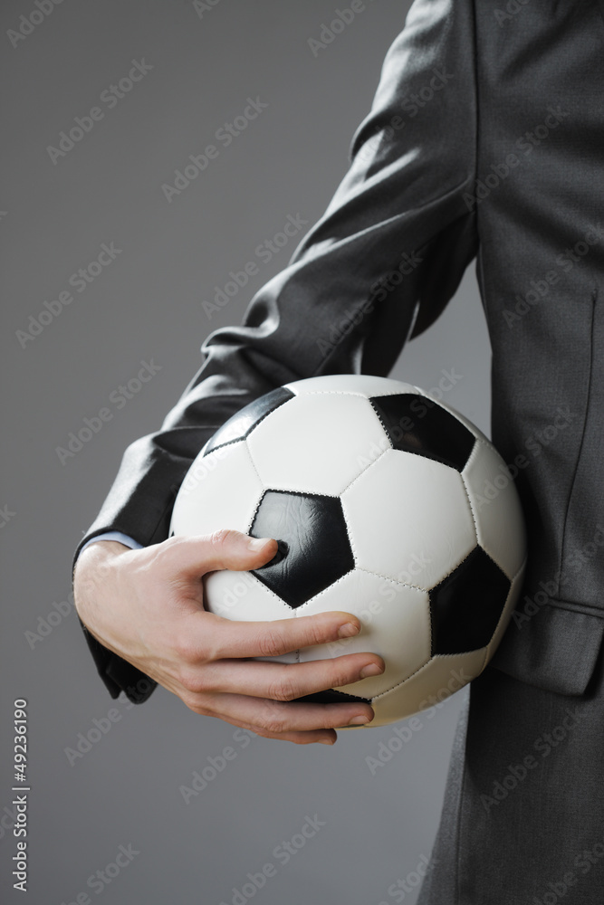 Elegant businessman holding a soccer ball Elegant businessman holding a soccer ball