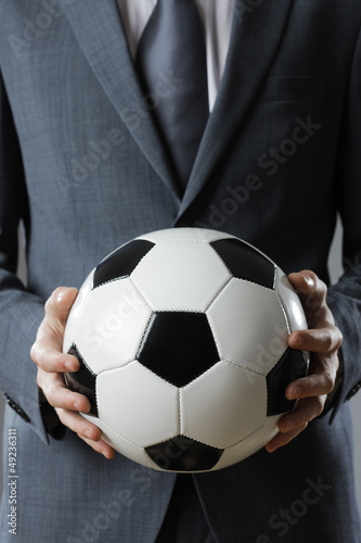 Elegant businessman holding a soccer ball © stokkete