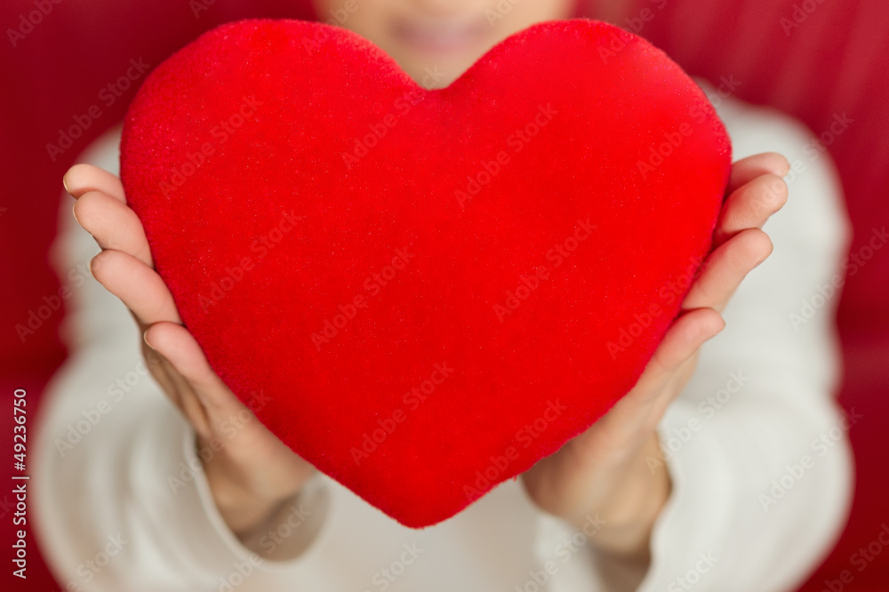 Beautiful woman holding heart in hand - care and love