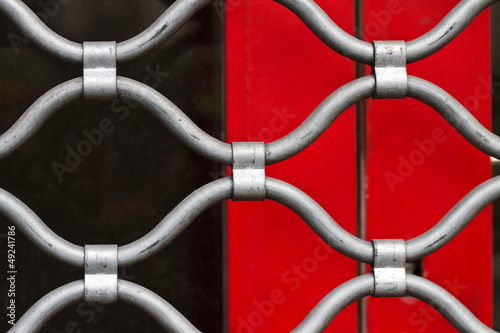 Grille de sécurité métallique sur fond rouge et noir