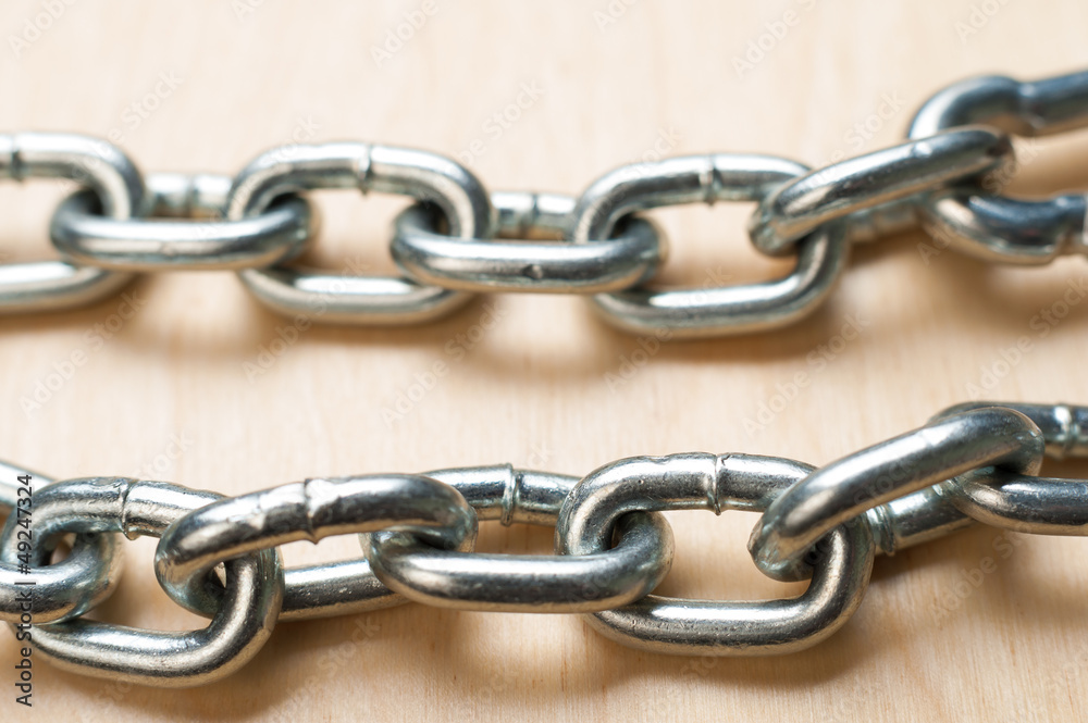 Two Chain Links on Wooden Table Two Chain Links on Wooden Table